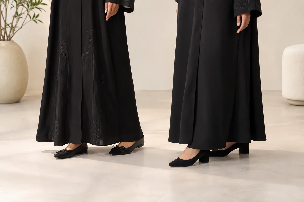 Two abaya hem examples with flat shoes and low heels, kept clear of the floor