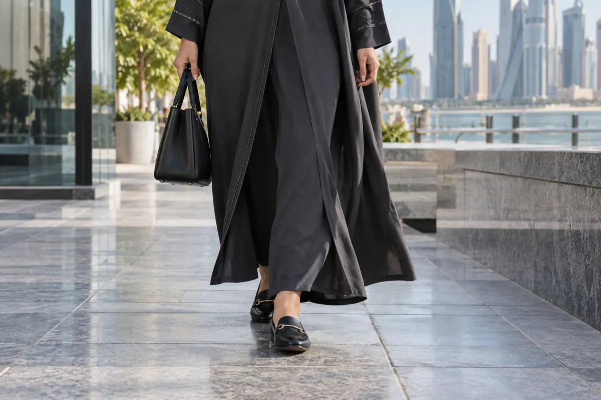 Loafers and an abaya hem are checked during an ordinary walking step